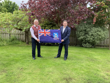 Craig Hoy MSP and Neil Rankin holding the flag of the Falklands Islands